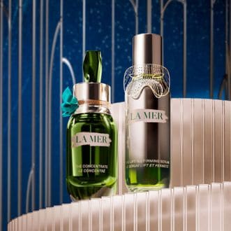 Close up of model applying serum to cheek, smiling